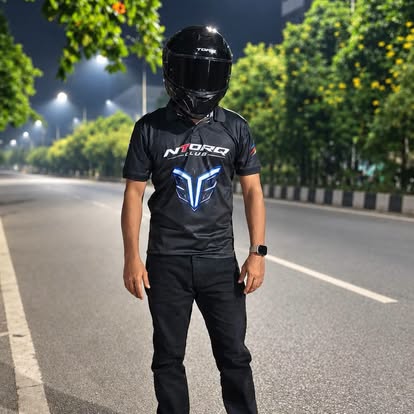 Rider wearing the black NTORQ Club jersey outdoors at night